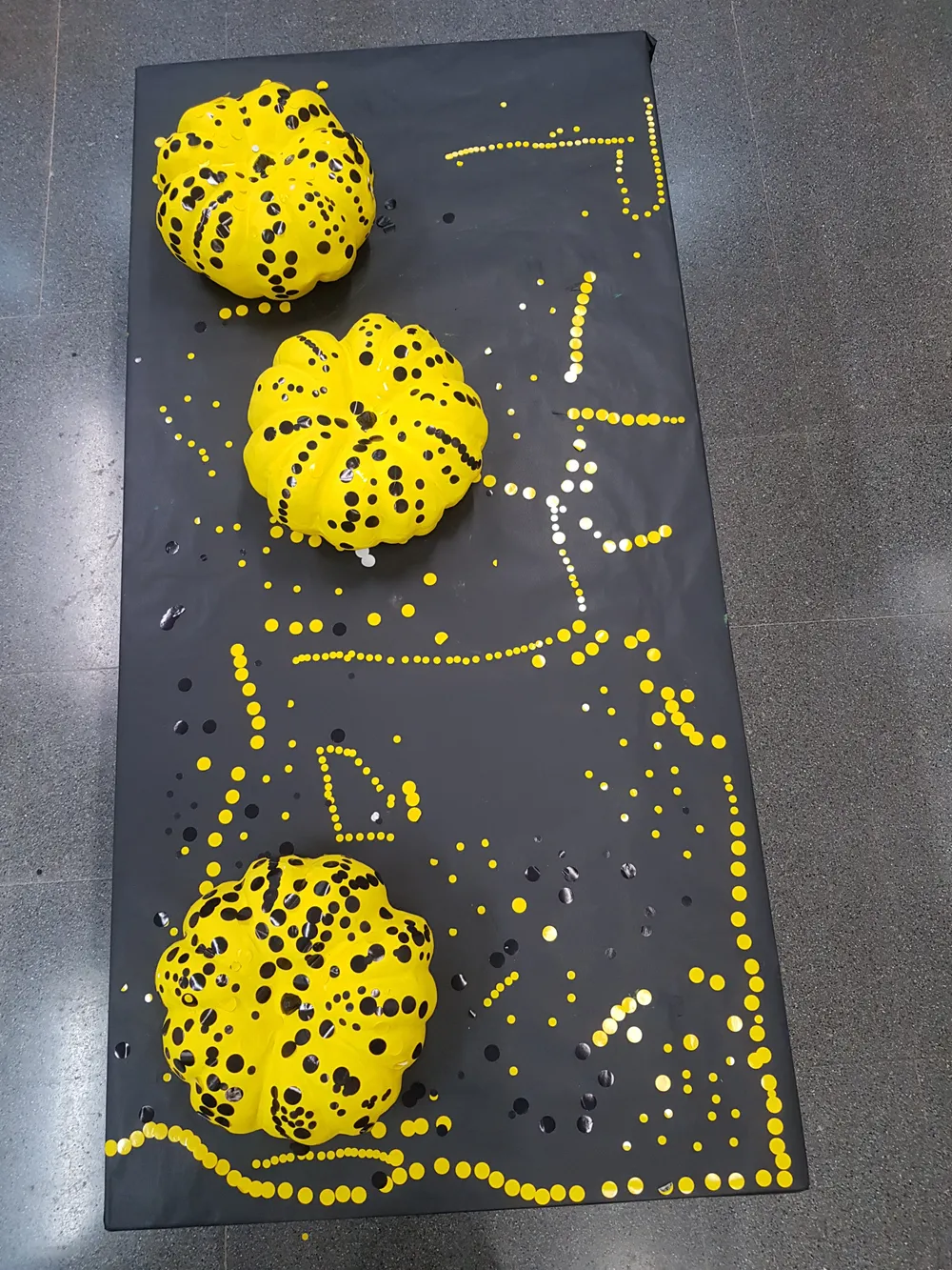 Carbasses pintades de groc amb punts negres sobre una superfície fosca decorada amb punts grocs